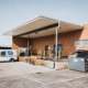 A loading dock with a postal delivery truck and trash bin in a city setting.