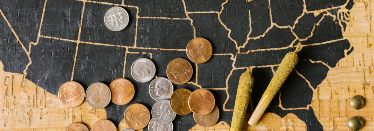 A USA map with cannabis joints and coins, symbolizing legal marijuana and its economic impact.