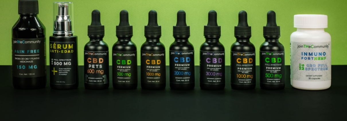 Array of CBD products including oils and serums displayed on a green backdrop.