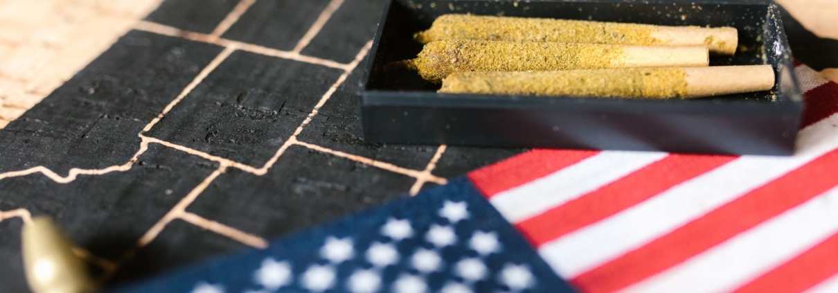 Cannabis joints in a tray with an American flag on a map background.