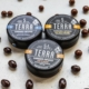 Close-up of cannabis-infused chocolate edibles in tin containers, creatively scattered.