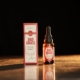 Close-up of Dad Grass full spectrum CBD tincture bottle and box on a warm wooden surface.