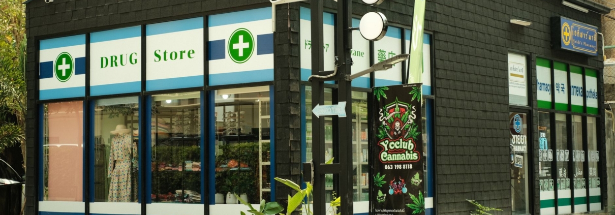Modern urban drug store with cannabis signage and green exterior plant decor.
