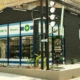 Modern urban drug store with cannabis signage and green exterior plant decor.