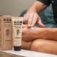 Person applying hemp-infused cream with packaging visible, promoting skincare benefits.