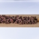 Purple cannabis buds laid out on rolling paper for preparation.
