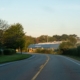 Serene evening view of a winding road leading to a building with natural surroundings in Holland, Michigan.