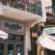 Street view of a CBD and vape store with decorative balcony in an urban area.